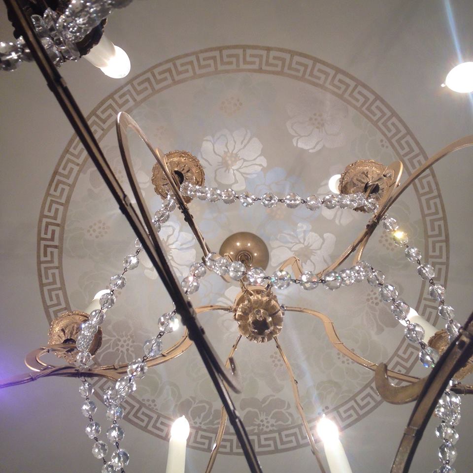 Ceiling chandelier medallion hand painted with Greek key border and shimmering floral field. Interior design by Christine Huve 