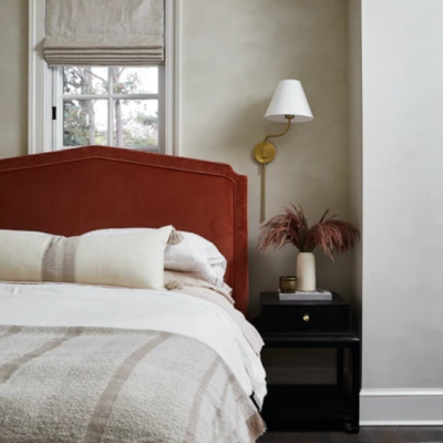 Red accents of an upholstered headboard in a guest room.